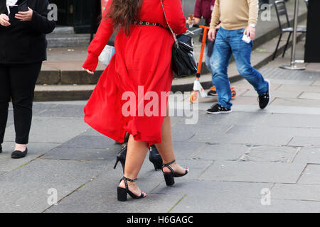Femme avec une robe rouge marcher dans la ville Banque D'Images