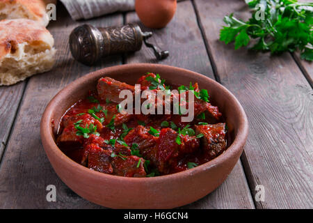 La viande en sauce de tomate rôti de bœuf dans un bol d'argile Banque D'Images