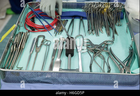 Les instruments de chirurgie, pinces et ciseaux, scalpels, placé dans un bac dans la salle d'opération Banque D'Images