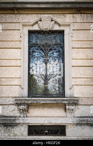 Fenêtre d'une ancienne villa italienne avec grille artistique fait main. Banque D'Images