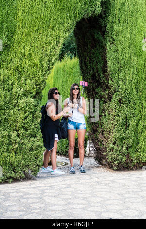 Deux jeunes femmes touristes prenant en selfies le jardin de l'Alhambra, Grenade, Espagne. Banque D'Images