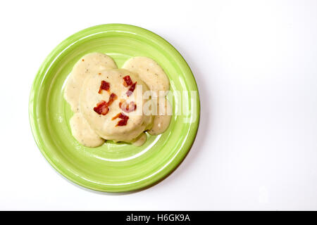 Petits gâteaux et sauce sur une plaque verte isolée sur fond blanc Banque D'Images