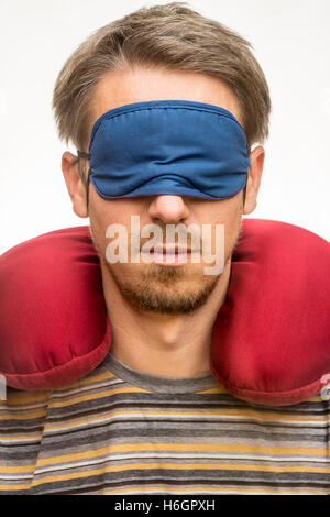 Homme barbu avec masque de sommeil oreiller de voyage et rouge sur fond blanc libre Banque D'Images