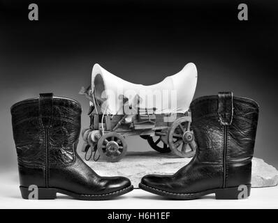 Kids cowboy bottes noires et chuck wagon avec prix pour votre type en noir et blanc. Banque D'Images