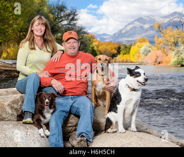 Portrait plein air de couple marié avec leurs trois chiens le long de la rivière Arkansas, Colorado, USA ; Salida Banque D'Images