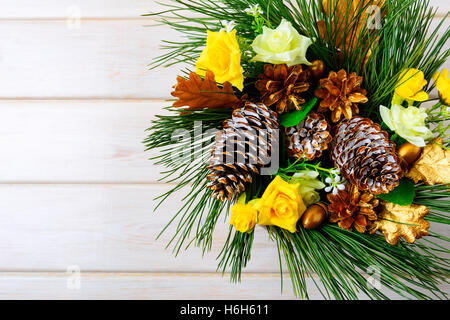 Noël arrière-plan avec des roses en soie jaune d'or et de cônes de pin. Partie de la décoration de Noël. Noël arrière-plan. Banque D'Images