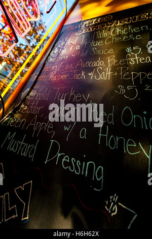 Vue grand angle d'un menu à la main sur un tableau noir dans un café. Banque D'Images