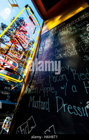 Vue grand angle d'un menu à la main sur un tableau noir dans un café. Banque D'Images