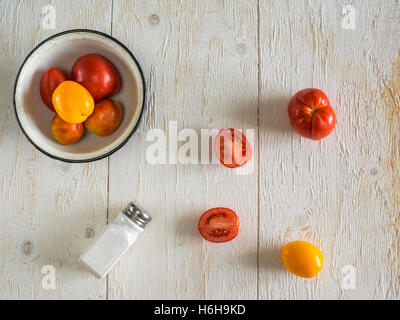 Les tomates et les salières et poivrières sur table en bois Banque D'Images