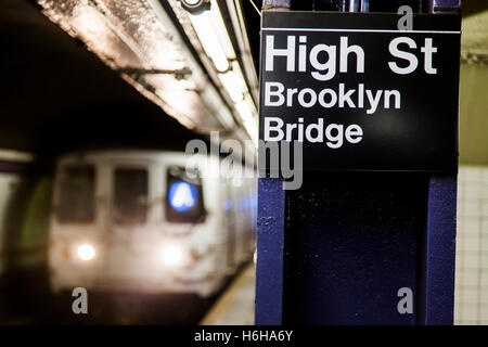 Subway train approchant derrière l'enseigne représentant c'est la High Street station Pont de Brooklyn de Brooklyn, New York. Banque D'Images