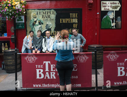 Le quartier de Temple Bar de Dublin, République d'Irlande. Une femme prend une photo d'un groupe d'amis à l'extérieur d'un pub. La région est un Banque D'Images