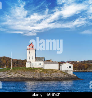 Tyrhaug phare, tour blanche avec le feu rouge sous ciel nuageux. Phare côtier situé dans la municipalité de Smola, More og Romsd Banque D'Images