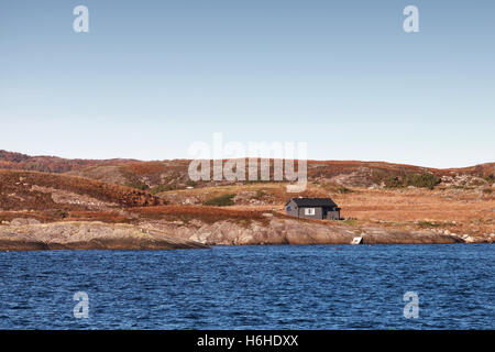 Petite maison en bois sur la côte rocheuse vide en Norvège Banque D'Images