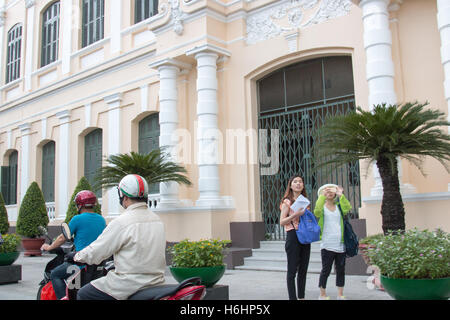 Les vietnamiens sur les scooters vélos équitation passé l'Hôtel de Ville bâtiment du Comité populaire de Ho Chi Minh ville, Saigon, Vietnam Banque D'Images