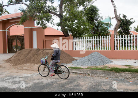 Dame vietnamienne woman riding son vélo dans la rue du côté de Hanoi, Vietnam Banque D'Images