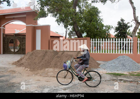 Dame vietnamienne woman riding son vélo dans la rue du côté de Hanoi, Vietnam Banque D'Images