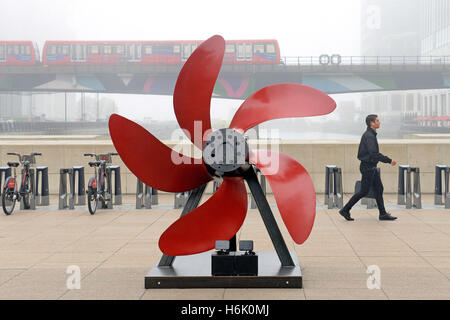 Un homme passe devant un abrégé pavot par l'artiste Mark Humphrey dans le cadre de la route de l'Art du souvenir à Canary Wharf, Londres. Banque D'Images