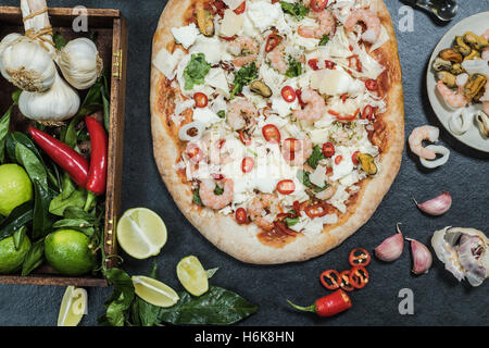 Ingrédients pour les fruits de mer pizza au feu de bois sain sur la croûte Banque D'Images