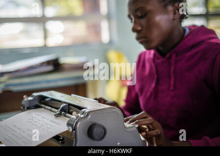 Un apprenant de l'école spéciale Eluwa types sur une machine à écrire pendant la leçon d'anglais à Windhoek, Namibie. Banque D'Images