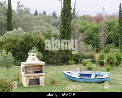 Vieux bateau utilisé comme coin salon barbecue à l'intérieur de la propriété en campagne de Corfou Banque D'Images