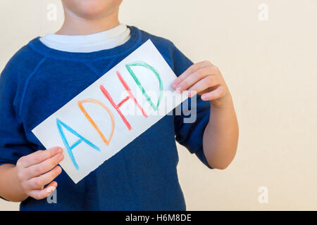 Jeune garçon est titulaire d'ADHD texte écrit sur la feuille de papier. Le TDAH est un trouble d'hyperactivité avec déficit de l'attention. Banque D'Images