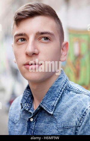 Portrait d'un adolescent homme rebelle sur un mur de graffiti background Banque D'Images