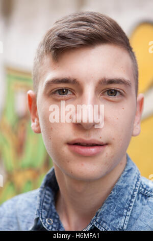 Portrait d'un adolescent homme rebelle sur un mur de graffiti background Banque D'Images