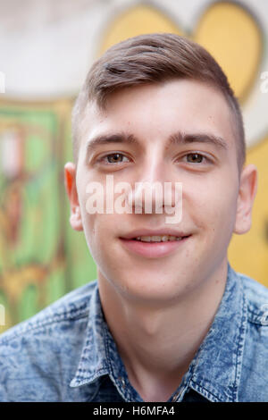 Portrait d'un adolescent homme rebelle sur un mur de graffiti background Banque D'Images