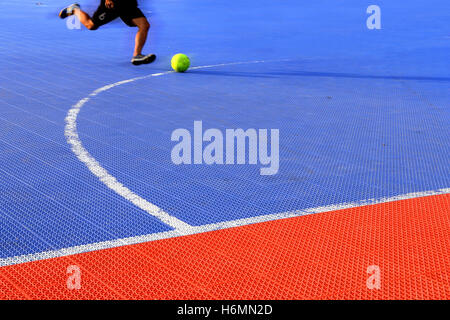 L'homme des coups de masse sur football futsal futsal. cour plastique texture carreaux marbre Banque D'Images