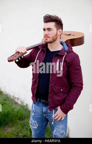 Beau cool homme portant une guitare sur ses épaules Banque D'Images