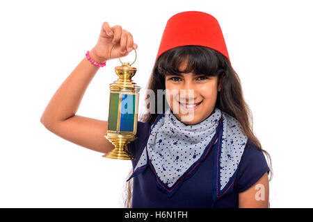 Happy Female Adolescent avec fez rouge Holding Ramadan Lantern isolé sur fond blanc Banque D'Images