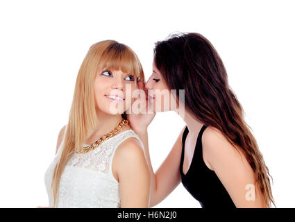 Deux sœurs adolescentes whispering isolé sur fond blanc Banque D'Images