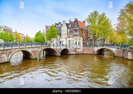 Amsterdam. L'eau et pont canal sur le coucher du soleil. La Hollande ou aux Pays-Bas. L'Europe. Banque D'Images