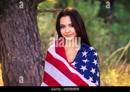 Beau modèle pose avec le drapeau des Etats-Unis d'Amérique dans le parc d'été Banque D'Images