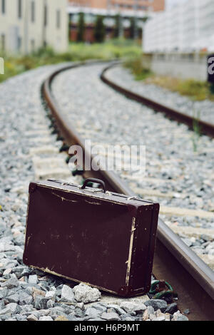 Une vieille valise marron à côté de la voie ferrée Banque D'Images