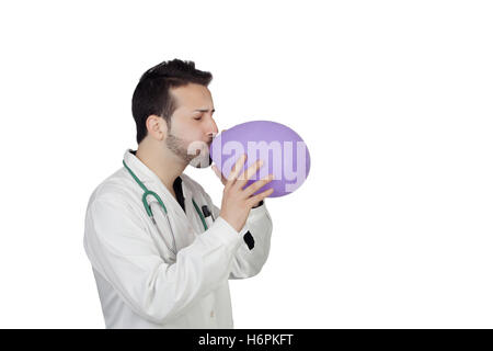 Jeune homme médecin Blowing Balloon Over White Background Banque D'Images