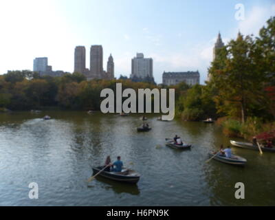 Bateaux à rame avec des couples dans Central Park, NY avec côté ouest tours de bureaux en arrière-plan Banque D'Images