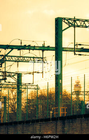 Ciel jaune au coucher du soleil plus de portiques et de fils électriques sur la ligne de chemin de fer hors de St Pancras International, Londres, Royaume-Uni, 2012 Banque D'Images