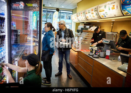 Les clients de l'intérieur manchester métro snack à emporter franchise établissement de restauration Boissons stockage réfrigérateur à l'intérieur du personnel s'alimentation Banque D'Images