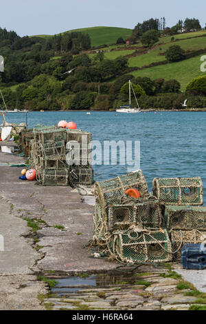 Des casiers à homard empilés sur le quai à Union Hall village de pêcheurs à Glandore Harbour, comté de Cork, Irlande. Banque D'Images