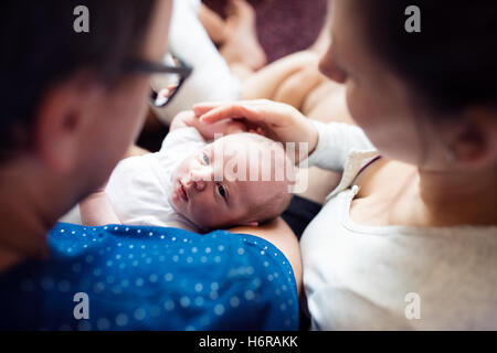 Les parents méconnaissables tenant leur fils nouveau-né, les baisers h Banque D'Images