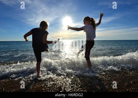 Ingelmunster, Sussex, UK. 31 octobre, 2016. Les enfants s'éclabousser dans la mer avec des glaces au cours de temps exceptionnellement doux. Crédit : Peter Cripps/Alamy Live News Banque D'Images