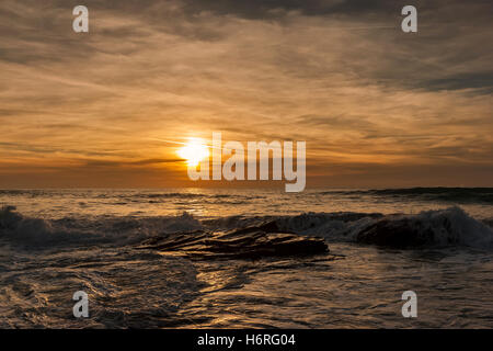 Météo France : Booby's Bay Sunset sur la marée haute. 31 octobre 2016. Riche or Soir, roulant dans les vagues scintillantes sur un ressort de la marée haute. Banque D'Images