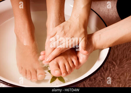 Relaxation santé femme femme fleur fleurs peau douce plante profiter pied pieds parfum crème pétales soucoupe dépenses de luxe Banque D'Images