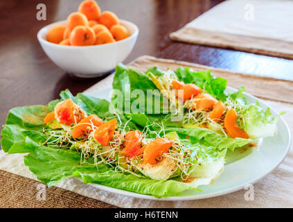 Servant de vegan salade avec les feuilles de laitue et d'abricot frais Banque D'Images