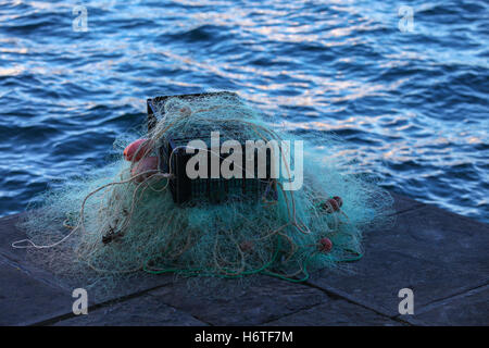 Boîte en plastique plein de rouge blanc filet de pêche, d'immenses chars la corde de nylon utilisés dans l'industrie de la pêche nylon tricotés à flotteur en polystyrène. Banque D'Images