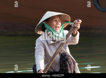 Femme au chapeau conique bateau canotage sur la rivière à Hoi An Banque D'Images