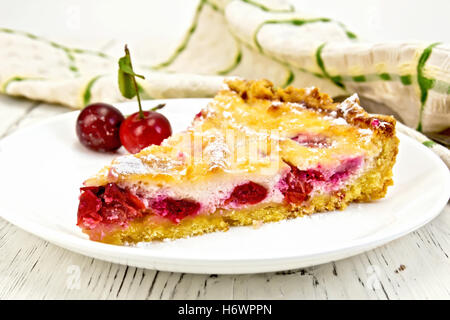 Tourte aux cerises et de la crème dans un plat, serviettes sur un fond de panneaux de bois Banque D'Images