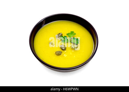 Purée de potiron soupe de persil et de graines dans un bol brun isolé sur fond blanc Banque D'Images