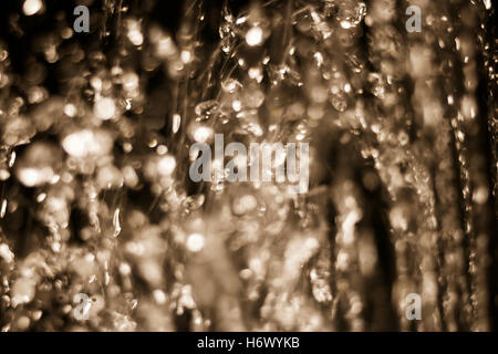 Les gouttes d'eau flou artistique voler dans l'air, fond de l'eau brouillée en tons de couleur marron clair Banque D'Images